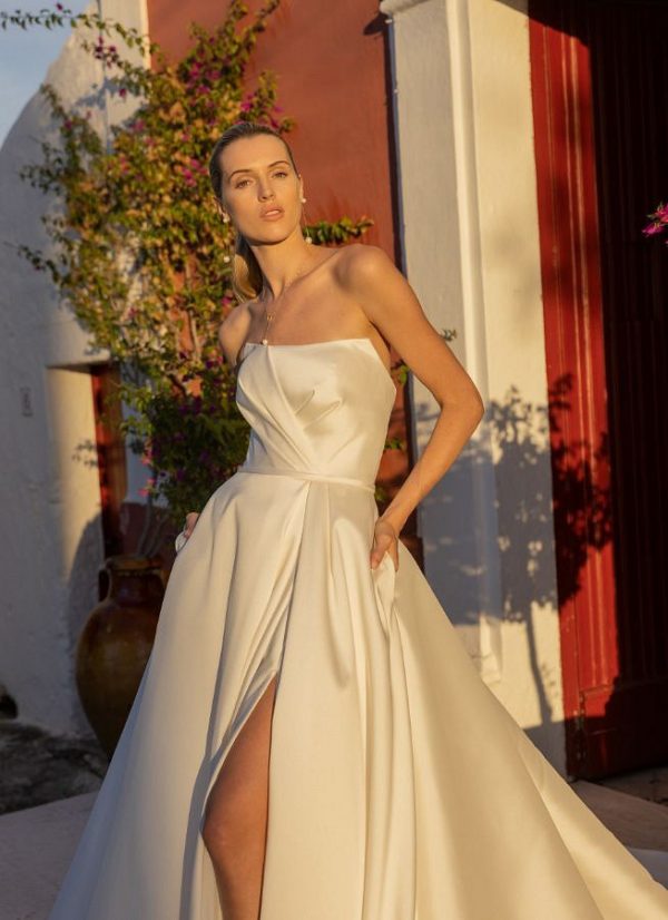 Agata Brautkleid, zeitlose Eleganz, romantische Braut, trägerloses Brautkleid, plissiertes Oberteil, praktische Taschen, hoher Schlitz im Rock, modeca Brautmode